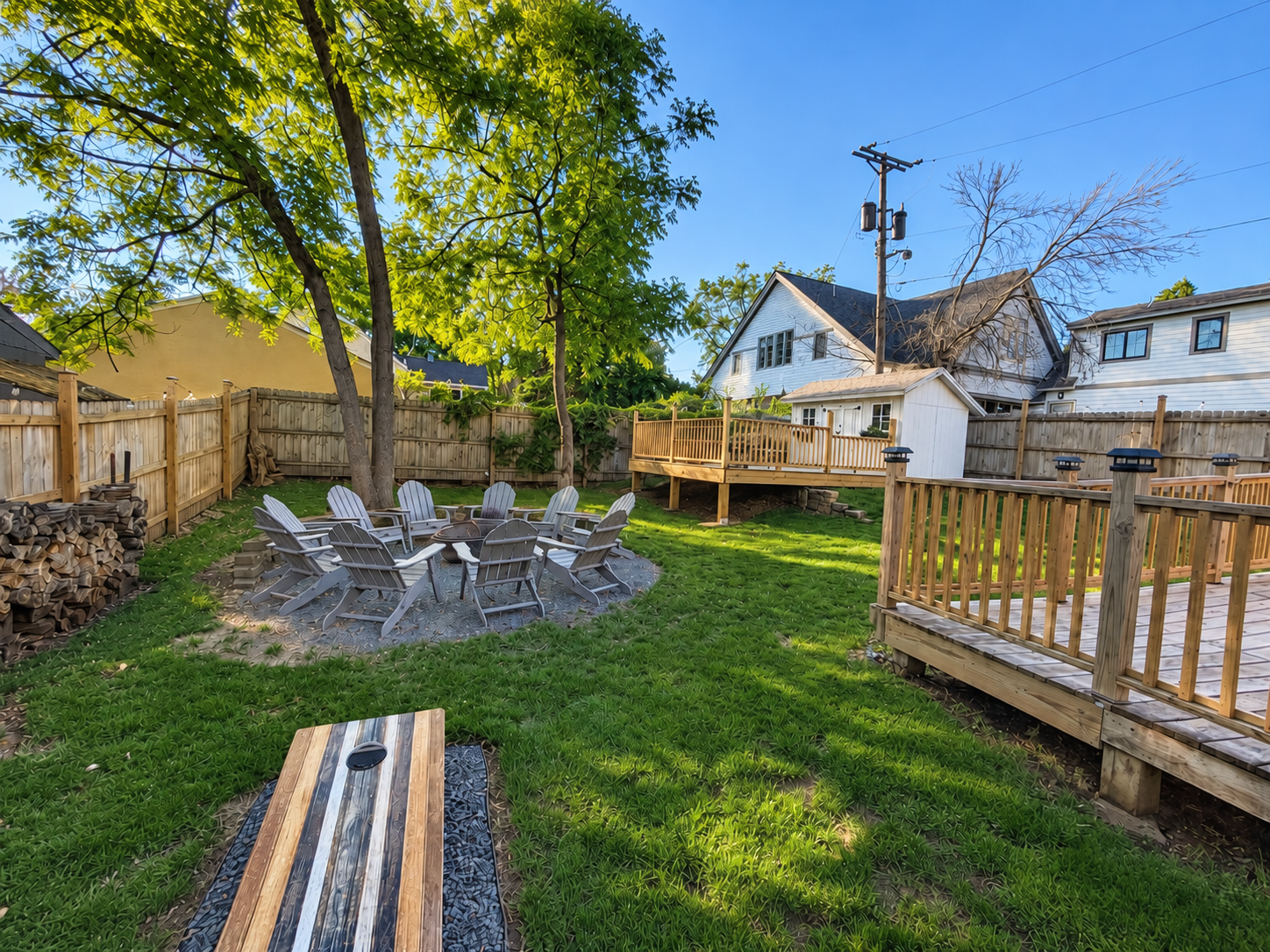 Hidden Gem backyard with fire pit chairs, lawn games, and a wooden deck