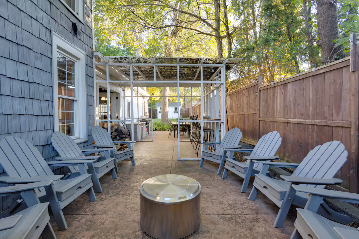 White pergola, patio chairs, and fire pit at River Valley Retreats
